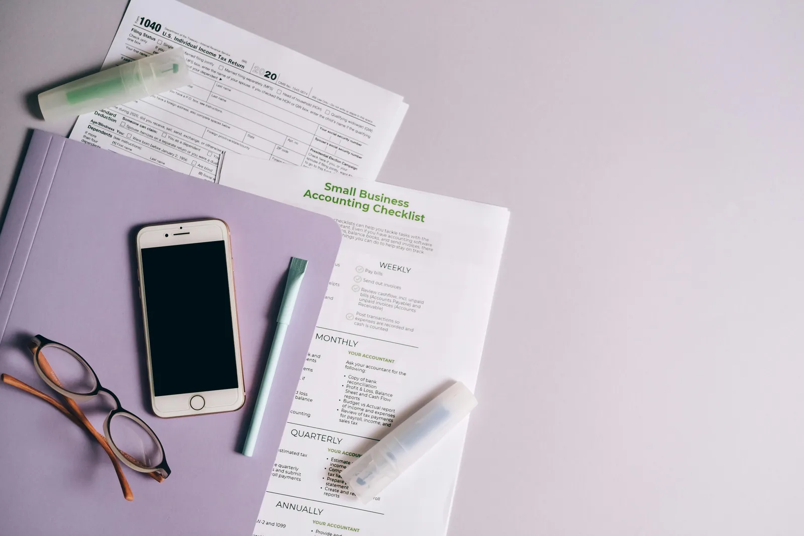 Desk layout with finance paperwork, phone, and glasses.